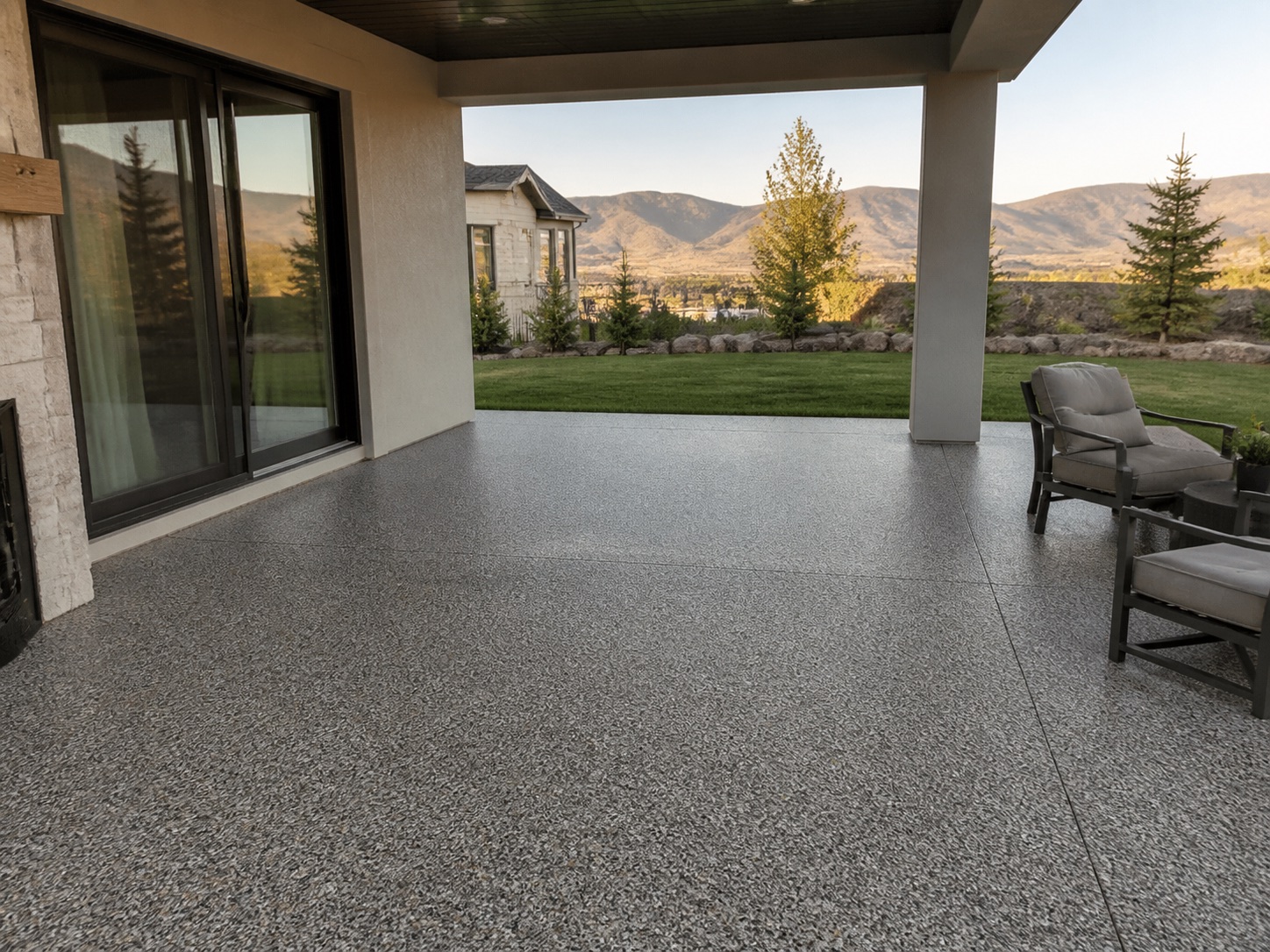 Covered residential patio with a textured gray floor and mountain views
